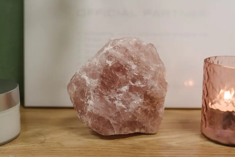 Rozenkwarts zoutlamp met brandende kaarsen in de salon